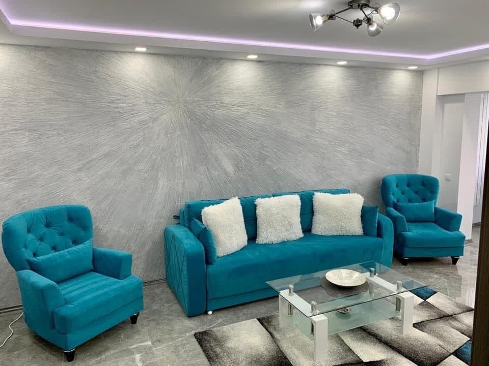 A finished living room with a feature wall, new lighting and a polished floor