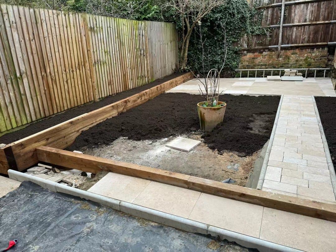 A timber raised bed beside the new stone patio