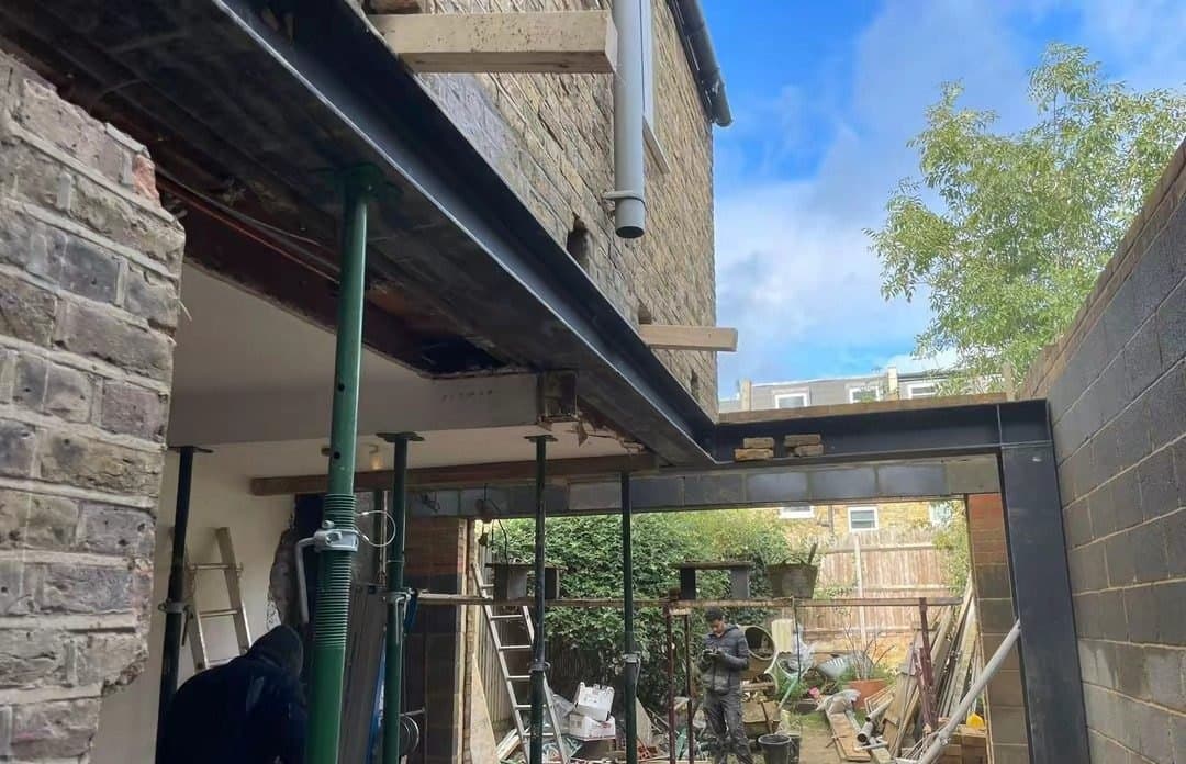Steel beams propped in place across a rear knock-through