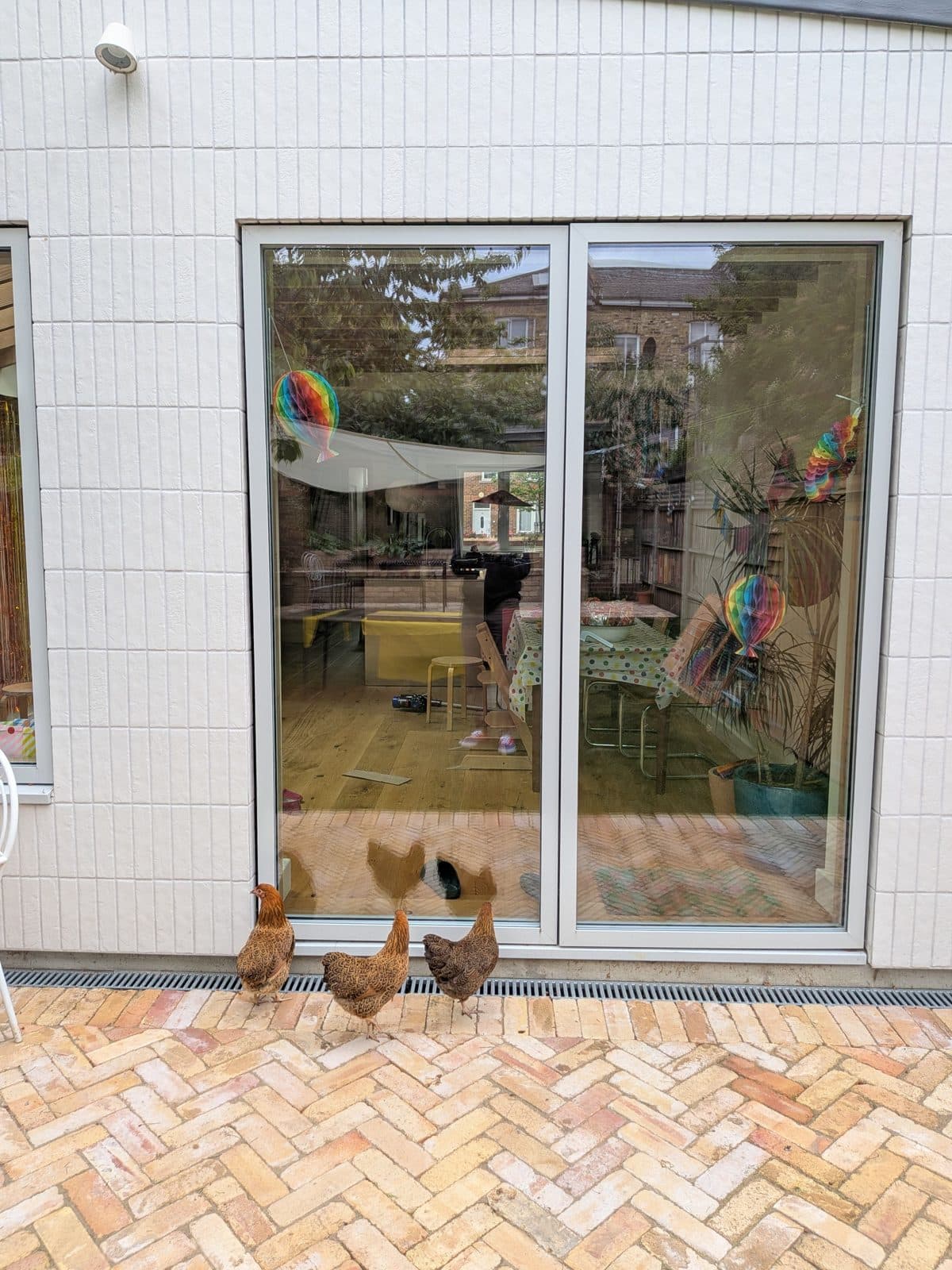Herringbone brick paving laid up to a pair of sliding doors