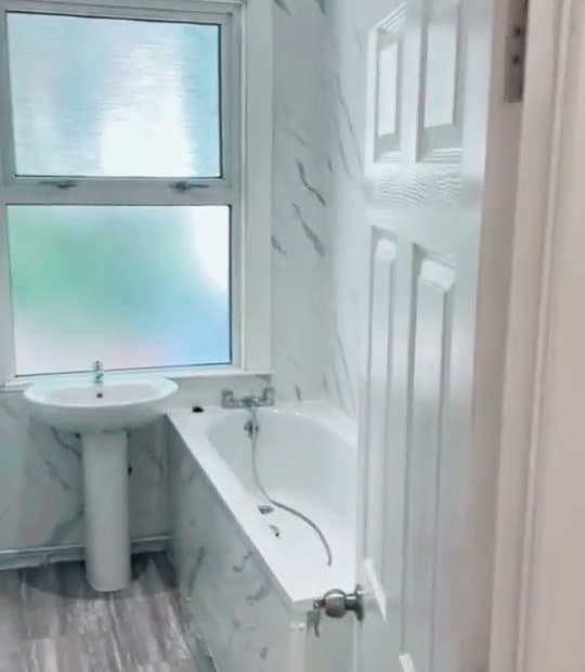 A finished white bathroom with a bath and basin